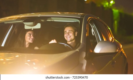 The Happy Man And Woman Drive A Car. Evening Night Time