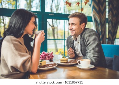 The happy man and woman eating a cake in the cafe - Powered by Shutterstock