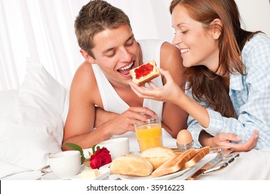 Happy Man And Woman Having Luxury Hotel Breakfast In Bed Together