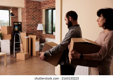 Happy Man And Woman Moving Together In New Family House To Start Lifestyle Beginnings. Buying First Apartment Flat And Celebrating Life Event, Decorating Property Space With Furniture.