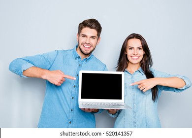 Happy Man And Woman Showing Laptop And Pointing On Black Screen.