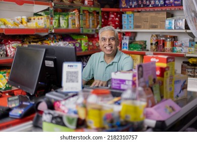  Happy man working as a cashier at supermarket - Shutterstock ID 2182310757