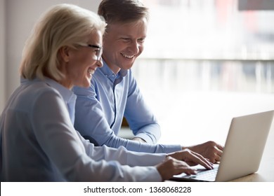 Happy Manager And Client Having Friendly Conversation At Meeting With Laptop, Smiling Broker Consulting Customer Showing Computer Funny Presentation Laughing Talking Watching Online At Work In Office