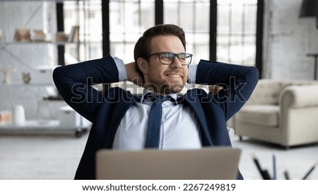 Happy manager relaxing at workplace in office, enjoying work break and stress relief after completing task. Satisfied business leader resting on chair at desk with laptop, breathing cool fresh air