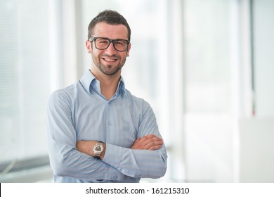 Happy manager standing with his arms crossed - Shutterstock ID 161215310