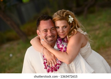 Happy Married Couple Embracing And Celebrating Their Vow Renewal Ceremony On A Tropical Beach