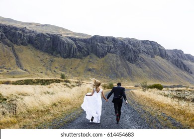 Happy Married Couple Running Down Country Road