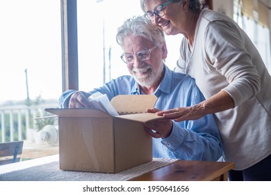 Happy Mature Aged Older Family Couple Unpacking Carton Box, Satisfied With Internet Store Purchase Or Unexpected Gift, Feeling Excited Of Fast Delivery Shipping Service, Positive Shopping Experience.