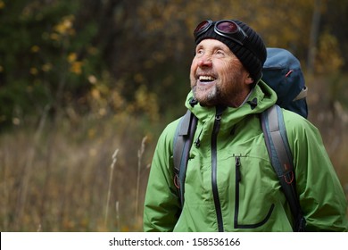 Happy mature backpacker in an autumn forest - Powered by Shutterstock