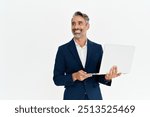 Happy mature business man using laptop standing isolated on white background. Middle aged professional businessman ceo executive wearing suit holding computer working online looking away at copy space