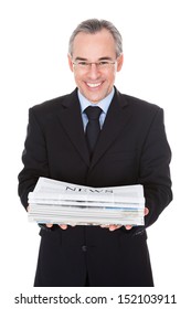 Happy Mature Businessman Holding Stack Of Newspaper Over White Background