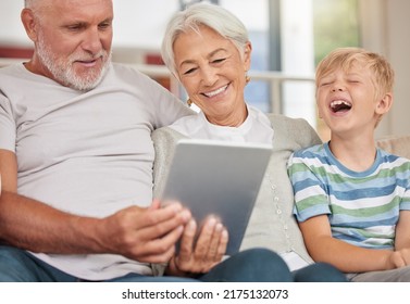 A Happy Mature Couple Bonding With Their Grandchild While Babysitting And Using A Digital Tablet For Video Call At Home. Grandparents Relaxing With Their Cute Little Grandson And Browsing