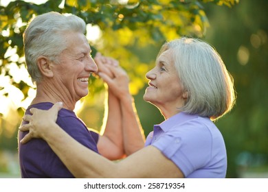 Happy Mature couple dancing in autumn park on sunset