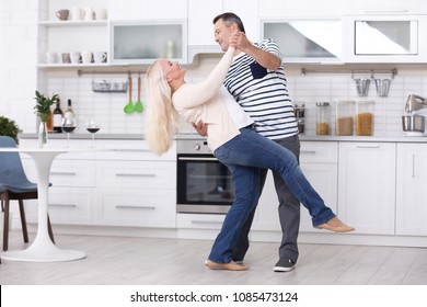 Happy Mature Couple Dancing In Kitchen