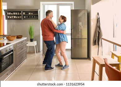 Happy Mature Couple Dancing In Kitchen