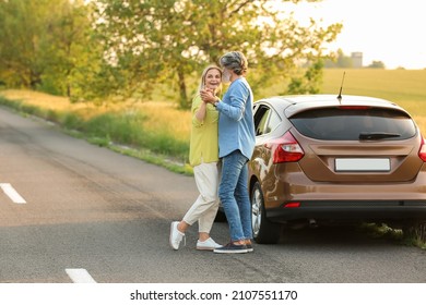 Happy Mature Couple Dancing Near Car Outdoors