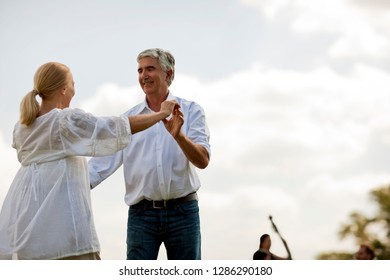 Happy Mature Couple Dancing Outside.