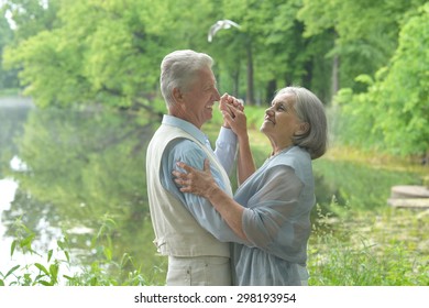 Happy Mature couple  dancing in the park in summer day