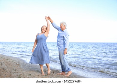 Happy Mature Couple Dancing At Sea Resort