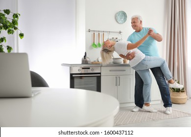 Happy Mature Couple Dancing Together In Kitchen