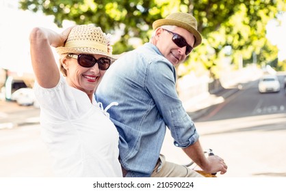 Happy Mature Couple Going For A Bike Ride In The City On A Sunny Day