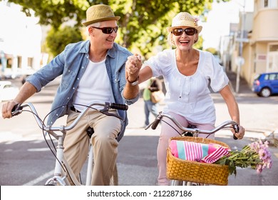 Happy Mature Couple Going For A Bike Ride In The City On A Sunny Day