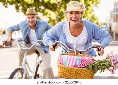 Happy Mature Couple Going For A Bike Ride In The City On A Sunny Day