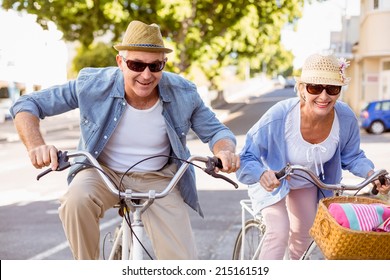 Happy Mature Couple Going For A Bike Ride In The City On A Sunny Day