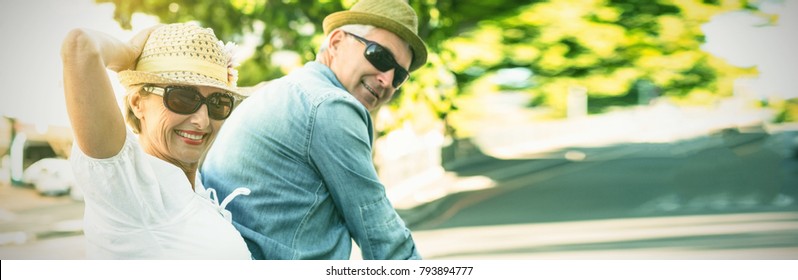 Happy Mature Couple Going For A Bike Ride In The City On A Sunny Day