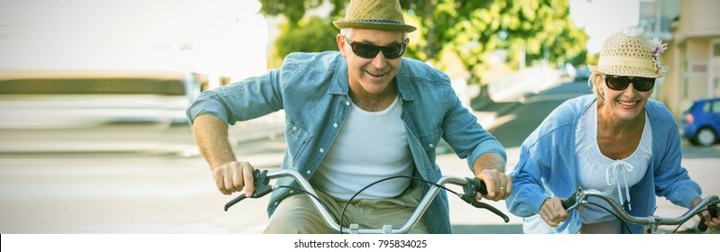 Happy Mature Couple Going For A Bike Ride In The City On A Sunny Day