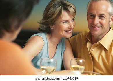 Happy Mature Couple Having A Good Time On Dinner With Their Friends