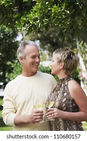 Happy Mature Couple Holding Wine Glasses Outdoors