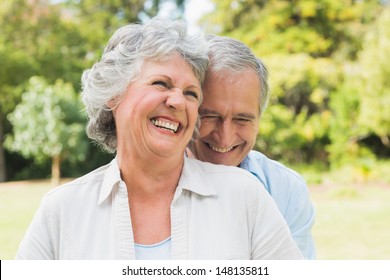 Happy Mature Couple Laughing In The Park On Sunny Day