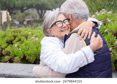 Happy mature couple in love embracing outdoor in the park, grey haired husband and wife smiling, family enjoying tender moment, happy marriage, sincere feelings - Powered by Shutterstock