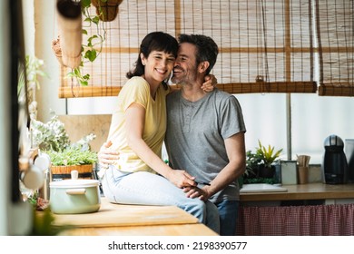 a happy mature couple showing affection on the kitchen counter at home, love senior people.