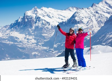 Happy Mature Couple Skiing In The Alps Mountains. Senior Man And Woman Enjoying Ski Vacation In Alpine Resort. Active Retirement. Healthy Winter Sport For Every Age.