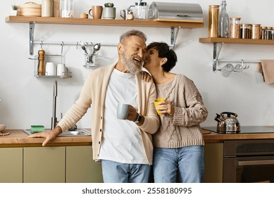 A happy mature couple smiles together while enjoying coffee in a modern kitchen. - Powered by Shutterstock