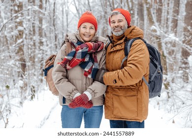 Happy mature couple in a snowy forest - Powered by Shutterstock