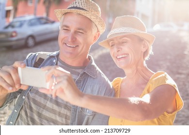 Happy mature couple taking a selfie together in the city on a sunny day - Powered by Shutterstock