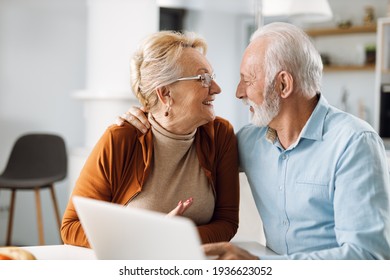 Happy mature couple  talking to each other while using computer - Powered by Shutterstock