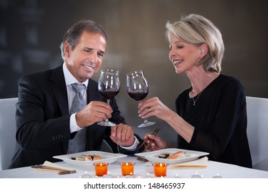 Happy Mature Couple Toasting Wine In A Elegant Restaurant - Powered by Shutterstock