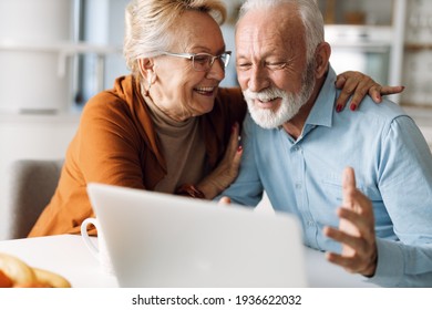 Happy  mature couple using  laptop at home - Shutterstock ID 1936622032
