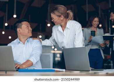 Happy Mature Female Boss Discussing Online Project With Employee Showing Presentation To Experienced Team Leader. Business And Communication Concept