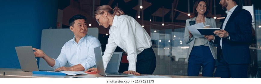 Happy Mature Female Employee Discussing Online Project, Showing Presentation To Skilled Team Leader.