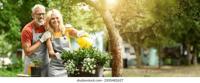 Happy Mature Gardeners Couple In Aprons Tending To Plants In Backyard, Loving Senior Spouses Watering Flowers And Smiling At Camera, Older Man And Woman Enjoying Retirement Leisure, Copy Space - Powered by Shutterstock