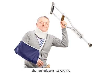 A Happy Mature Gentleman With Broken Arm Holding A Crutch Isolated On White Background