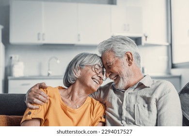 Happy mature husband and wife sit rest on couch at home hugging and cuddling, show care affection, smiling senior loving couple relax on sofa have fun, enjoy tender romantic family weekend together - Powered by Shutterstock