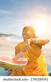 Happy Mature Indian Woman Cutting Watermelon At Vagator Beach