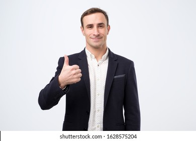 Happy Mature Italian Man In Suit With Thumbs Up Gesture Approving Your Choice, Isolated On White Wall