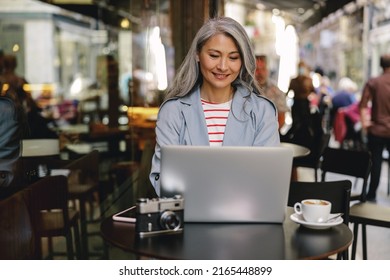 Happy Mature Lady Working At City Cafe